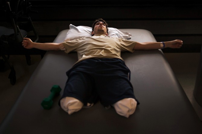 Jeff Bauman rests during occupational therapy at Spaulding Rehabilitation Hospital less than a month after having his lower legs blown off in the first of two pressure cooker bombs that exploded at the Boston Marathon. (Josh Haner, The New York Times - May 8, 2013)