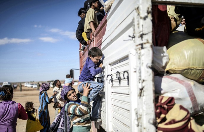 Syrian Kurds get into a truck after crossing the border between Syria and Turkey in Suruc, in the Sanliurfa province, on September 30, 2014. Tens of thousands of Syrian Kurds flooded into Turkey fleeing an attack by the Islamic State (IS) group. (Bülent Kılıç/AFP)