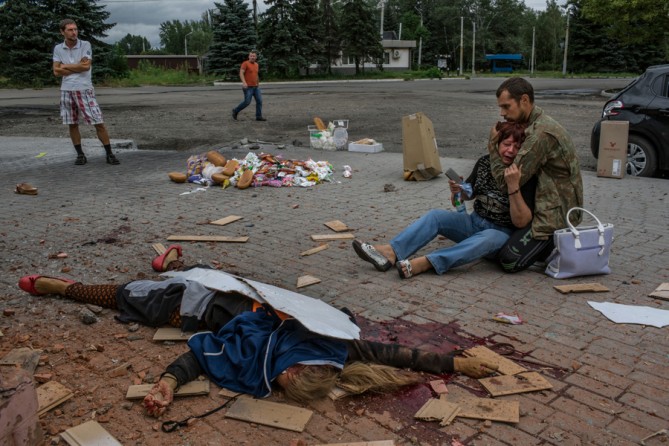 Aug. 19, 2014. A mother is comforted by her son, a pro-Russian rebel, in front of the body of her daughter, who died next to two other people in shelling by Ukrainian troops near a railway in Makeevka, east of Donetsk. (Mauricio Lima for The New York Times)