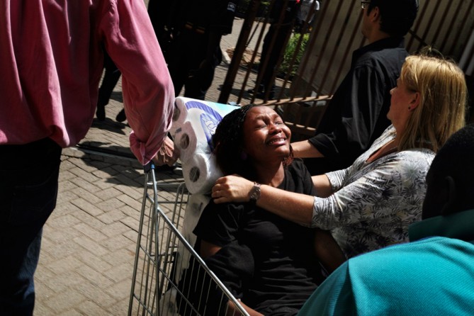 People were treated outside and Hicks raced among them. In this case a shopping cart and rolls of toilet paper served as a stretcher. (Tyler Hicks, The New York Times - September 21, 2013)
