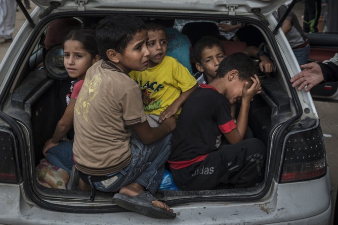July 23, 2014. Palestinian refugees fleeing fighting in their neighborhood arrive at a United Nations school used as a shelter in Khan Yunis, in southern Gaza. (Sergey Ponomarev for The New York Times)