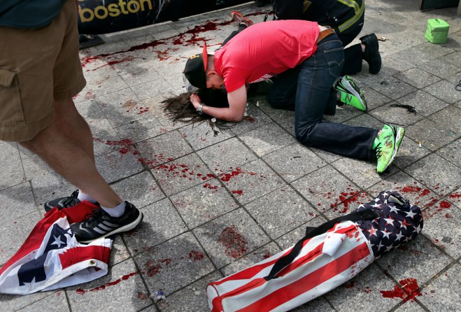 Joe Duncan comforts Sydney Corcoran at the site of the first bomb. She was standing with her parents Celeste and Kevin to cheer on her aunt, who was running in the race. She fell fifteen feet away from her mother, who lost both of her legs in the bombing. (Photo by John Tlumacki, April 16, 2013)