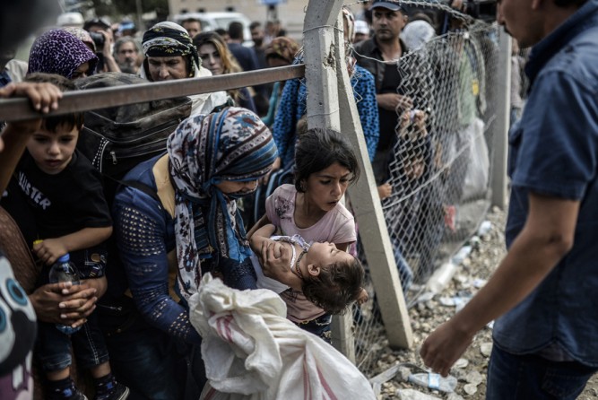 Syrian Kurds go back to Syria at the Mursitpinar crossing gate in the southeastern town of Suruc in Sanliurfa province, on September 24, 2014. The numbers of Kurdish refugees fleeing into Turkey to escape the advance of Islamic State jihadists in northern Syria has slowed considerably over the last few days, Turkish officials said on Wednesday. (Bülent Kılıç/AFP)