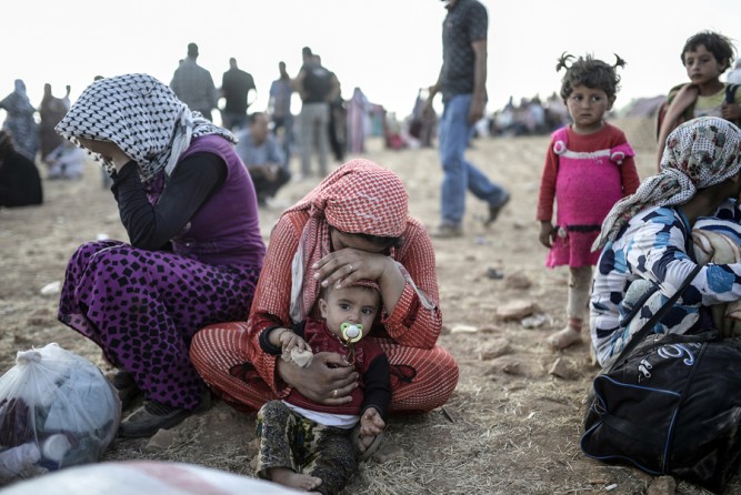 Syrian Kurds wait near Syria border at the southeastern town of Suruc in Sanliurfa province, on September 20, 2014. (Bülent Kılıç/AFP)