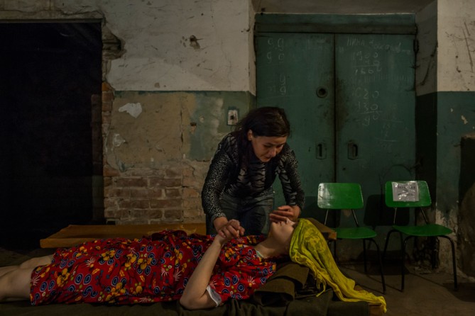 August 24, 2014. Alyona, 32, takes care of her friend Lyuba, 30, a hospital patient who was evacuated to its basement after an early-morning shelling that hit the hospital compound in central Donetsk. (Mauricio Lima for The New York Times)