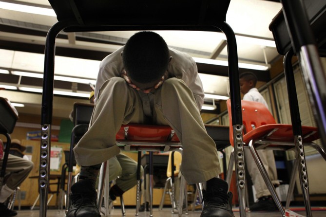 Tired from the day, Jordan Burns holds his face in his hands during Mr. Stafford-Glenn's fourth-grade class. Jordan was ordered several times to sit up straight and pay attention, but out of rebellion he ignored his teacher. (August 25, 2013)