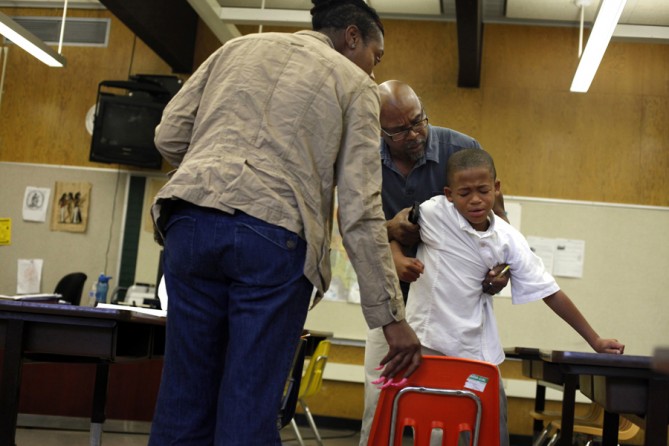 Crystal Watson-Johnson, Assistant to the Dean, and Dean Spencer Hooper try to console fourth-grader Delyon Rice after he was sent to the restoration room for punching his teacher. Students are sent to the restoration room for screaming, hitting teachers, fighting, or generally acting out. (August 25, 2013)