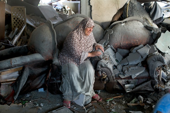 July 17, 2014. A woman as her family sifts through wreckage in a Gaza apartment building struck by Israeli explosives the night before. (Tyler Hicks/The New York Times)