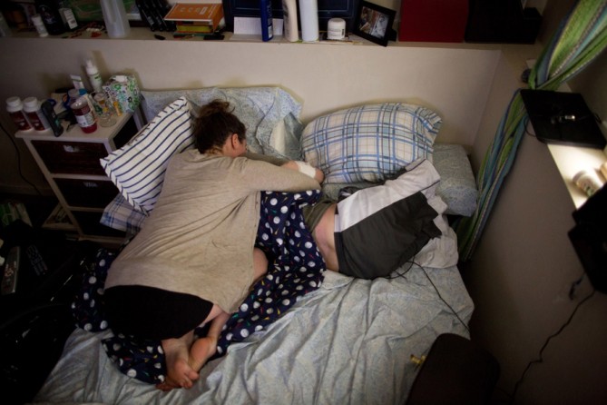 After a long day, Bauman's legs were sore when his girlfriend Erin, arrived.  She had recently started doing yoga near his house and was spending most nights sharing his bed at his mother's apartment, living out of her car. (Josh Haner, The New York Times - May 21, 2013)