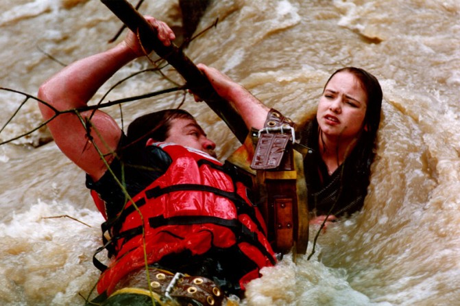 A local firefighter rescues a teenager from raging floodwaters.