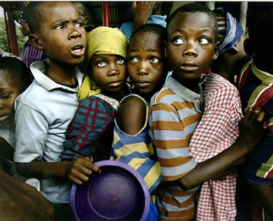HUNGER: Refugee children line up for a meager handout of rice, the only food they receive at the refugee camp where they are staying on the outskirts of Monrovia. (Carolyn Cole)