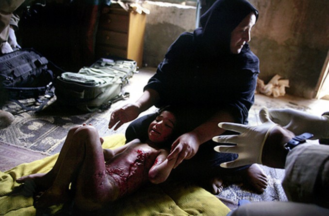 Screaming in pain from 10-day-old burns received during an aerial attack on Baghdad, Aya Hamad is comforted by her mother, Eimin Fvied. Later discovered by U.S. troops, the 6-year-old was transported to a local hospital for treatment. (David Leeson)