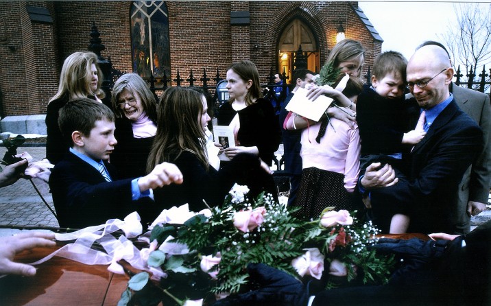 Carolynne's family places roses on her casket after the funeral. Friends and family dressed in pink, her favorite color. (12/8/07)