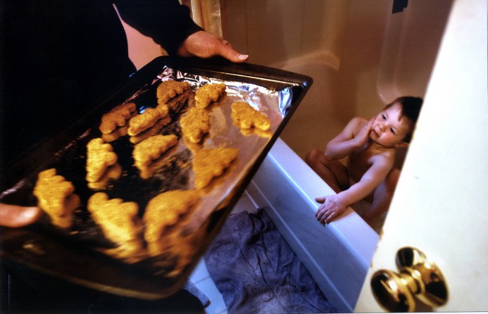 At EJ's request, Rich brings the dinosaur-shaped chicken nuggets into the bathroom where EJ can see them.