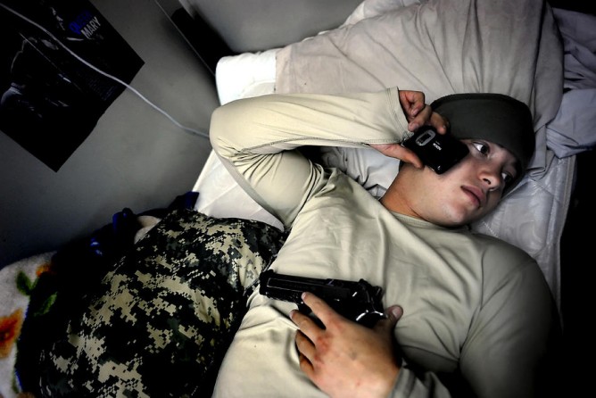 Fisher rests on his bed with his 9mm while calling a girlfriend back home Dec. 7, 2008.  A couple of weeks earlier, while communicating with friends on MySpace, he came to the realization that his on-again, off-again relationship with Kirsten Oliver was really over.  "It's one of those things, man," he said.  "You can’t really let it hit you.  Just continue with the mission... What the hell am I supposed to do?"  Soon after, he began calling a former girlfriend.  They talked about gettin