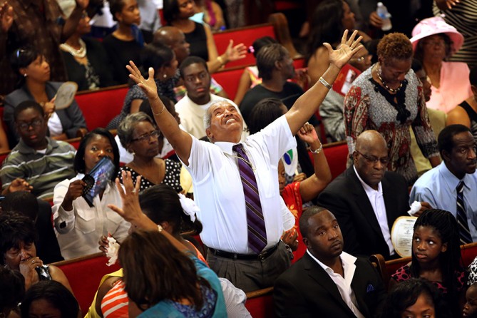 Jimmy Guyton stands in praise to sing at Emanuel AME Church on after the church reopened for the first service since its pastor, state Sen. Clementa Pinckney, and eight others were slain four days earlier during a Bible study. Guyton drove three hours from Greenville, S.C., to attend the service and honor Myra Thompson, who was among those killed (Paul Zoeller, The Post and Courier - June 21, 2015).