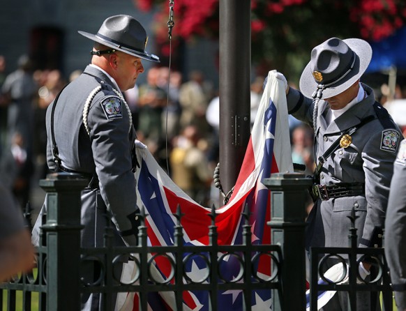 An honor guard from the South Carolina Highway Patrol removes the Confederate battle flag from the Statehouse grounds in Columbia, S.C. (Grace Beahm, The Post and Courier - July 10, 2015).