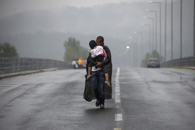 Syrian refugee kisses his daughter as he walks through a rainstorm towards Greece's border with Macedonia, near the Greek village of Idomeni (Yannis Behrakis, Thomson Reuters  - September 10, 2015). 