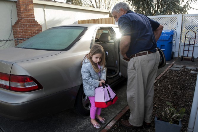 Eva, 5, holds two new Hello Kitty lunch boxes as she waits for her grandfather to finish loading her sister Ariel, 3, into the car.  (May 16, 2012)
