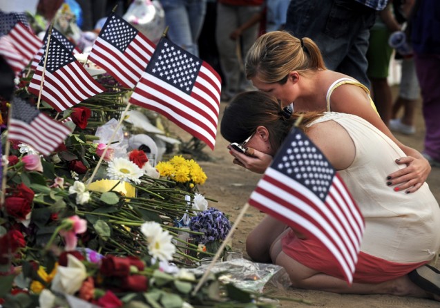 Amanda Medek, the sister of victim Micayla Medek, 23, is overcome with grief as she sits in front of a cross that was made for her sister. (Helen H. Richardson - July 22, 2012)