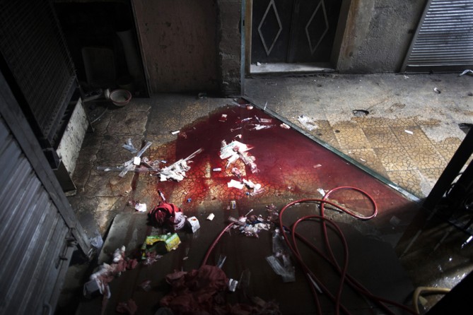 Blood and used medical supplies spill out of the back door of Dar al-Shifa hospital in Aleppo, Syria, Oct. 11, 2012. (Manu Brabo, Associated Press- October 11, 2012)