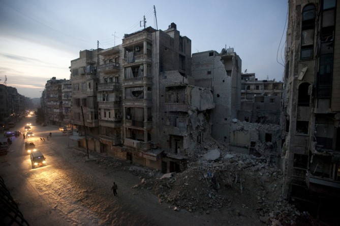 Night falls on a Syrian rebel-controlled area of Aleppo, Nov. 29, 2012, as destroyed buildings, including Dar Al-Shifa hospital, are seen on Sa'ar street after airstrikes targeted the area a week before. (Narciso Contreras, Associated Press- November 29, 2012)