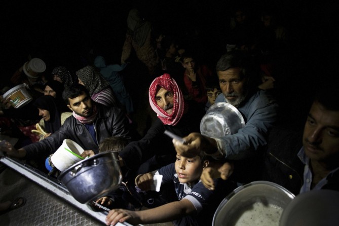 Displaced Syrian men wait for food near an NGO charitable kitchen in a refugee camp near Azaz, Syria, Oct. 23, 2012. Photo by Manu Brabo (Manu Brabo, Associated Press - October 23, 2012)