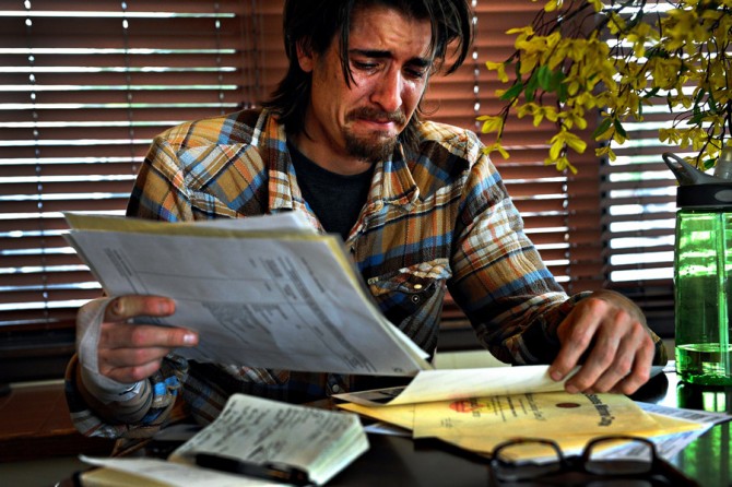 Scott looks over his military service records and weeps after being told his apartment application had been turned down. The leasing manager said he couldn't allow Scott to move in because of an assault charge on his background check. Though Scott had his honorable discharge papers and his good-conduct medal, Scott said they meant nothing. 'I'm not a criminal. You would think this would be worth something. It should be. It's not, though.'  (Craig F. Walker, The Denver Post - December 29, 2011)