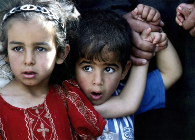 Fallujah - Displaced Iraqi children watch U.S. soldiers while waiting at a checkpoint before returning to their home in Fallujah. 