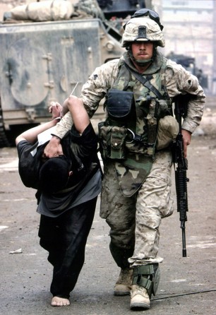 Fallujah - A U.S. Marine leads an Iraqi prisoner during fighting in the center of the city.