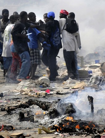 'Burn'  The smell of charred flesh lingers as Haitian survivors burn bodies and brandish knives while taking goods from stores in the market. Disorder erupted after the earthquake left Port-au-Prince in ruins. Security emerged as one of the most formidable challenges in the earthquake-shattered capital, limiting the ability of the United Nations and relief officials from elsewhere to distribute food and medicine. (Carol Guzy, The Washington Post - January 18, 2010)