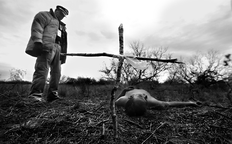 Rafael Hernandez, director of Angeles del Desierto stands over the body of an undocumented immigrant, after placing a cross he made of broken twigs. Hernandez came across the body while searching on a ranch just outside Falfurrias, Tx., on Wednesday Jan. 29, 2014. The death witnessed by a handful in South Texas was a precursor to the record number of Central American immigrants that were apprehended in 2014. (Bob Owen/San Antonio Express News)