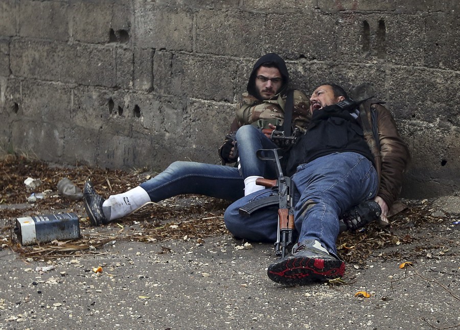 A Syrian rebel yells as he is hit by Army sniper fire as they prepared to attack a government controlled checkpoint in the Ain Tarma neighborhood of Damascus January 30, 2013. The rebel on the left would soon be hit by sniper fire. (January 30, 2013)