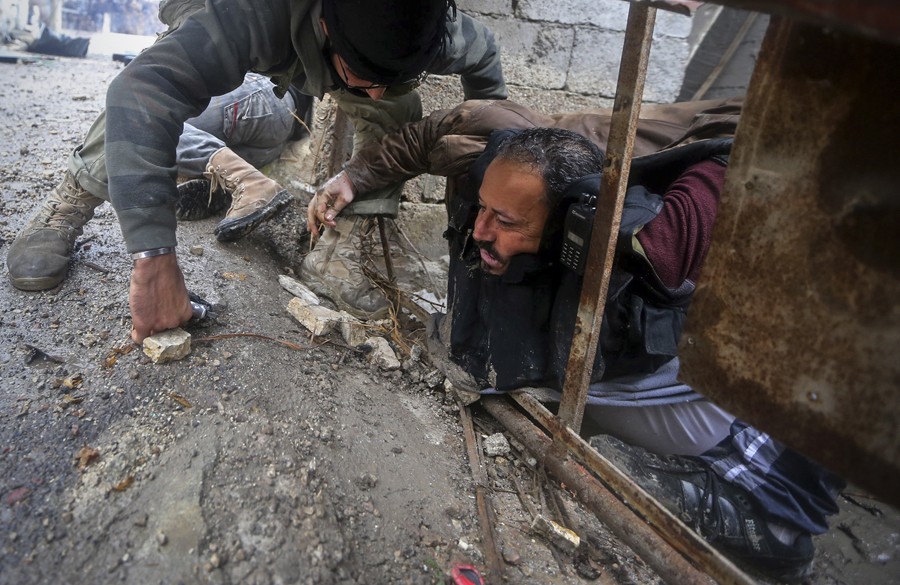 Syrian rebels pull a comrade who was shot by Army sniper fire during heavy fighting in the Ain Tarma neighbourhood of Damascus January 30, 2013. The man would die soon afterwards. (January 30, 2013)