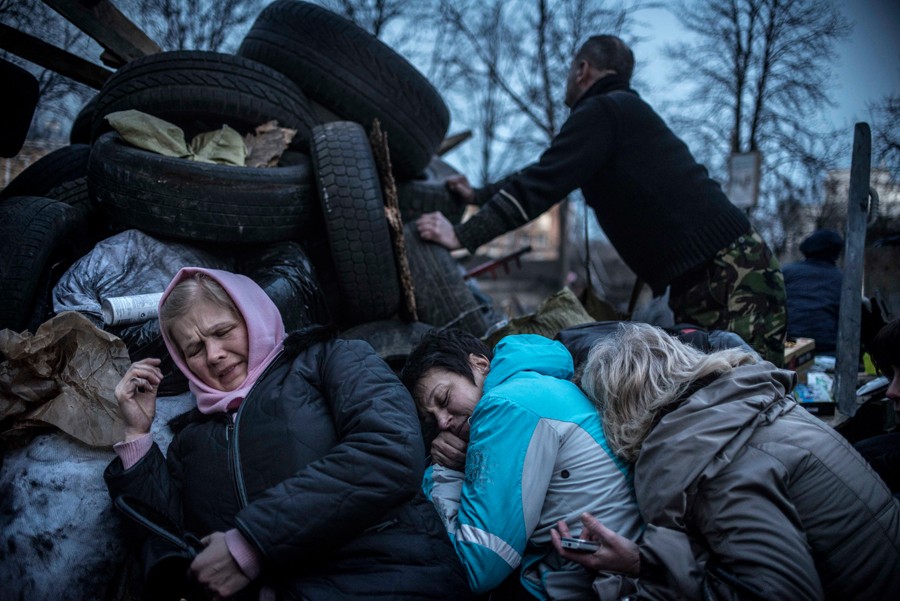Feb. 21, 2014. Women take shelter from sniper fire at the barricades in Kiev. (Sergey Ponomarev for The New York Times)