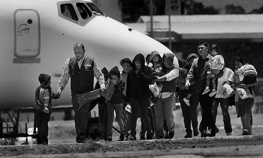 Guatemalan Goverment workers, in blue vests, escort mothers with their children from the plane after being deported from the U.S. Three planes, two full of adults and a third full of adults including 7 mothers and 13 children, arrived at the Guatemala Air Force side of La Aurora Airport in Guatemala City, Guatemala, on Tuesday, July 22, 2014. (Bob Owen/San Antonio Express-News)