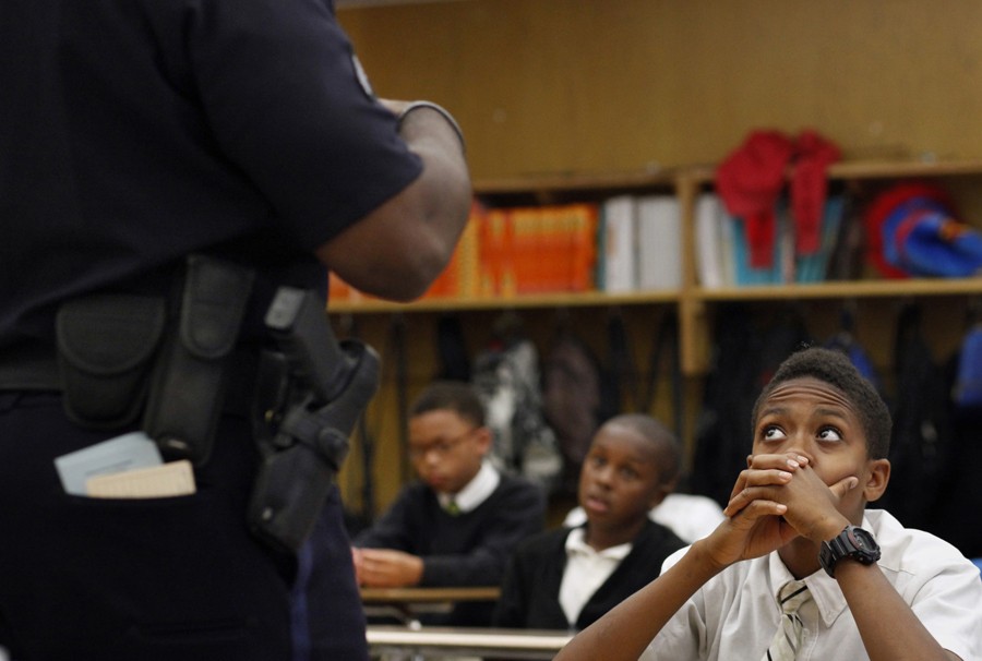Saud Nasir listens to Oakland Police Officer Damon Gilbert as he talks to the sixth grade class about the challenges of his job during career day. Because of the young boys' upbringing and the violence they witness on the street, many students don't trust the police. However, when confronted with an African-American police officer in the safety of the classroom, many of them began to warm up to his authority. (August 25, 2013)