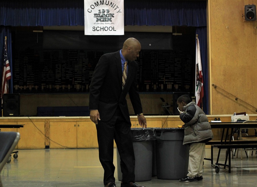 Principal Dr. Stanley Johnson encourages a student to finish his breakfast and go outside for the 'Scholar Holler' before school. In the morning, the students can come early for breakfast - a meal they may not otherwise receive in their homes. (August 25, 2013)