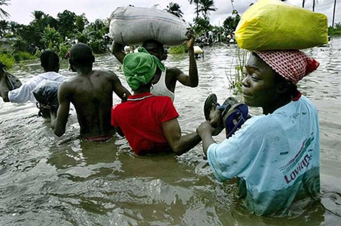 WATERY PATH: Unable to find food in government held areas, Liberians wade through swampland to buy food in rebel territory. (Carolyn Cole)