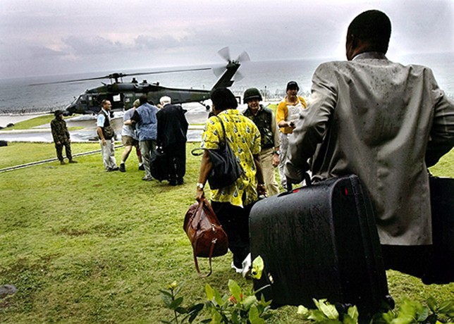 TIME TO LEAVE: Civilians, including aid workers, journalists and missionaries board a helicopter at the U.S. embassy in Monrovia in an effort to leave the war-torn country as the violence continues to escalate. (Carolyn Cole)