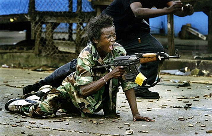 FIRING BACK: A government soldier defends a bridge in central Monrovia where a standoff between rebel and government forces held the city under siege. (Carolyn Cole)