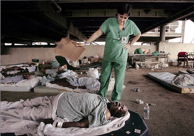 New Orleans, LA -- Memorial Medical Center nurse, Mary Jo D'Amico, fanned a patient waiting in the hospital's parking garage for helicopter transport from New Orleans. 