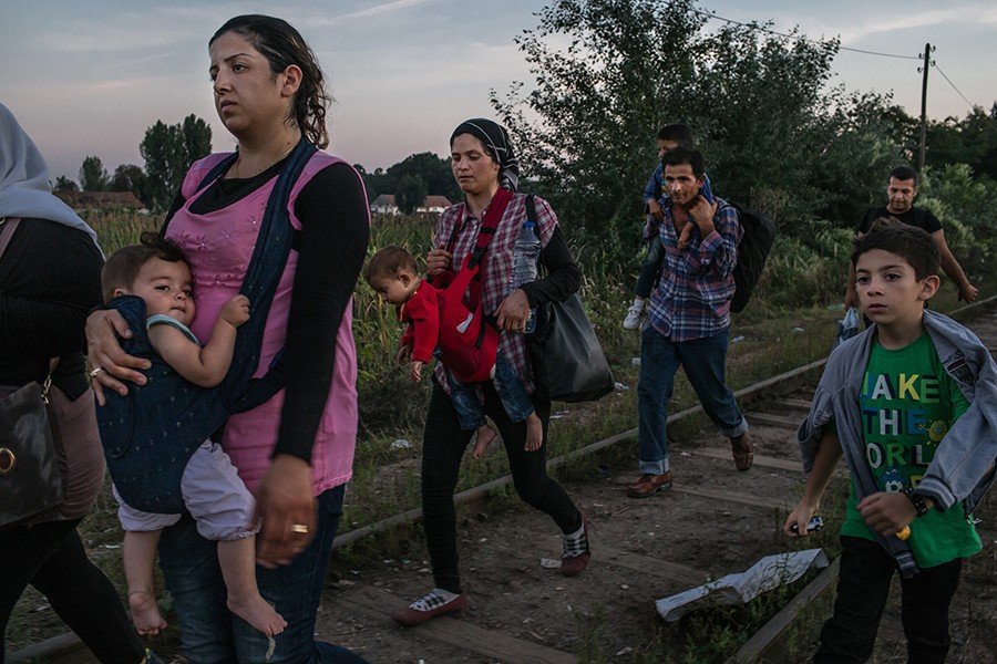 Roujin Sheikho, at left, from Syria, carries her daughter Widad as her son Nabih, at right, walks with her and other Syrian refugees down the railway before crossing into Hungary from Horgos, Serbia (Mauricio Lima, The New York Times - August 30, 2015). 