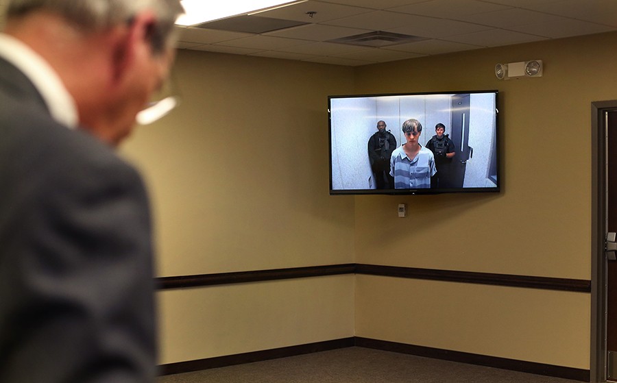 Ninth Circuit Public Defender Ashley Pennington addresses his client, Dylann Storm Roof, appearing via video from the county jail, during a bond hearing in North Charleston. Families of the nine people slain by Roof, 21, got their first look at the killer during the hearing. They surprised the world by offering him prayers and forgiveness. (Grace Beahm, The Post and Courier - June 19, 2015).