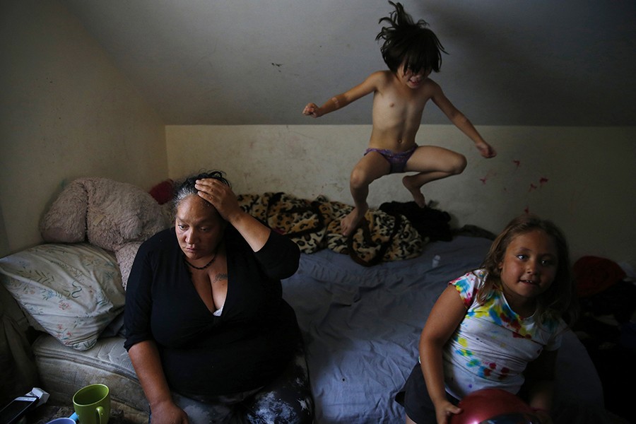 A Life Unraveling -- Heroin and other opioids have devastated Massachusetts families, killing an estimated 1,200 people last year and unraveling the lives of countless more. For Raquel Rodriguez, drugs have been the one constant in her life. High on heroin, after being clean for eight months, a frustrated Raquel Rodriguez begs her daughter Estrella to stop jumping on the bed in their apartment in East Boston (Jessica Rinaldi, The Boston Globe).