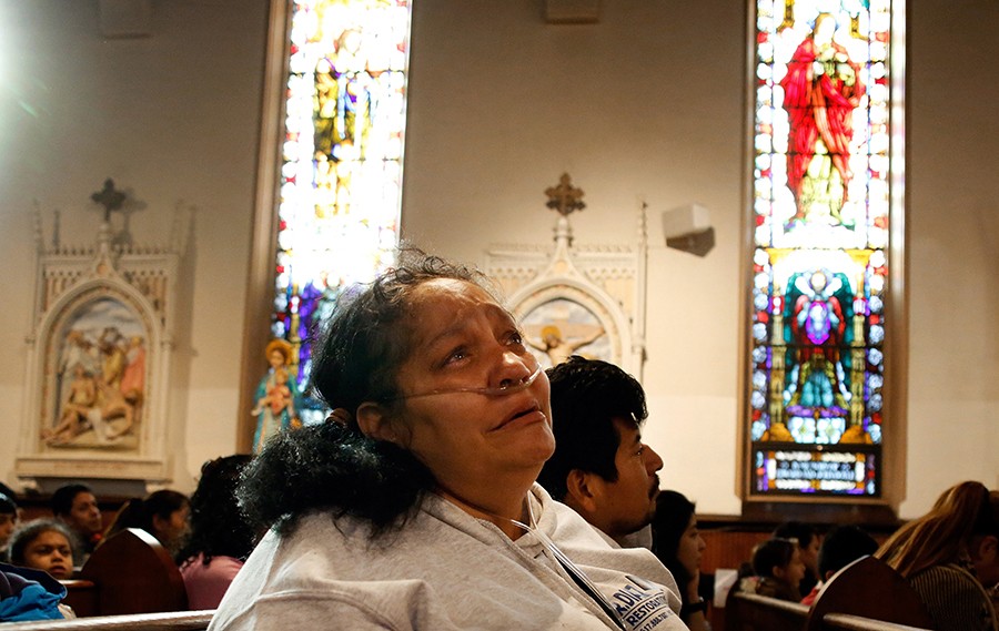 After a bout with pneumonia, Jose started taking her to church. At the end of Mass the children's choir starts to sing and Raquel breaks down, missing her daughters (Jessica Rinaldi, The Boston Globe).