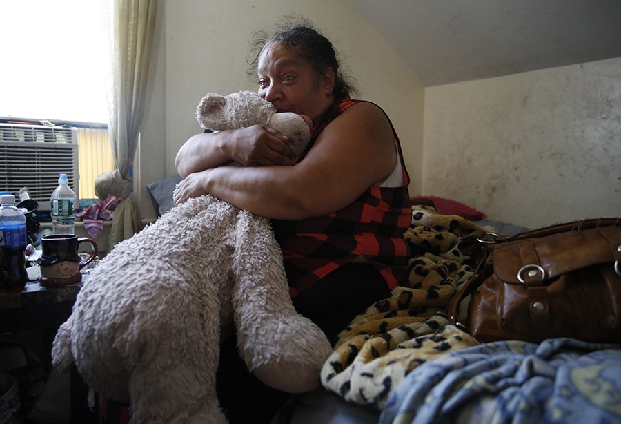 Sitting on her daughters' bed, Raquel clutches Estrella's giant teddy bear and cries for her children. "I want my babies." (Jessica Rinaldi, The Boston Globe).