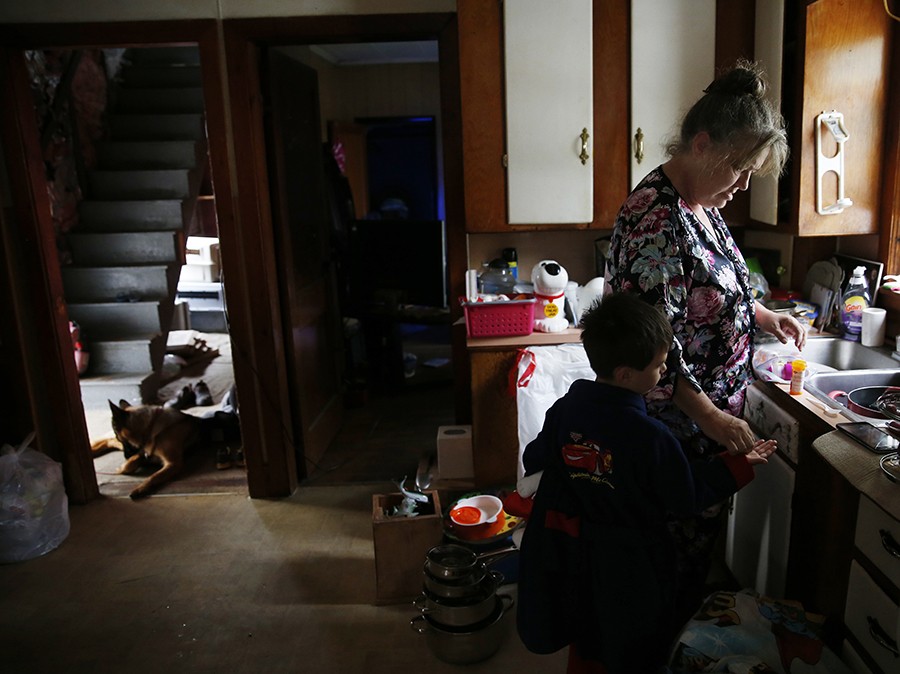 Strider, who takes multiple medications resulting from his early childhood abuse, gets his morning meds from Lannette in their new home. "We haven't been here 24 hours, and I'm tired already," Lanette said (Jessica Rinaldi, The Boston Globe).
