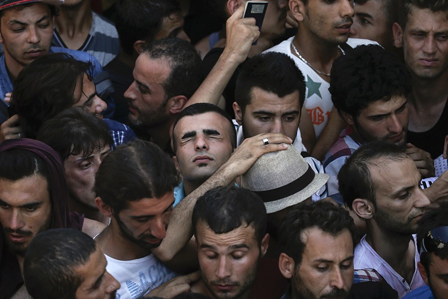 Syrian refugee tries to catch his breath as he stands in a crowded line to get registered in the national stadium of the Greek island of Kos (Alkis Konstantinidis, Thomson Reuters - August 12, 2015). 