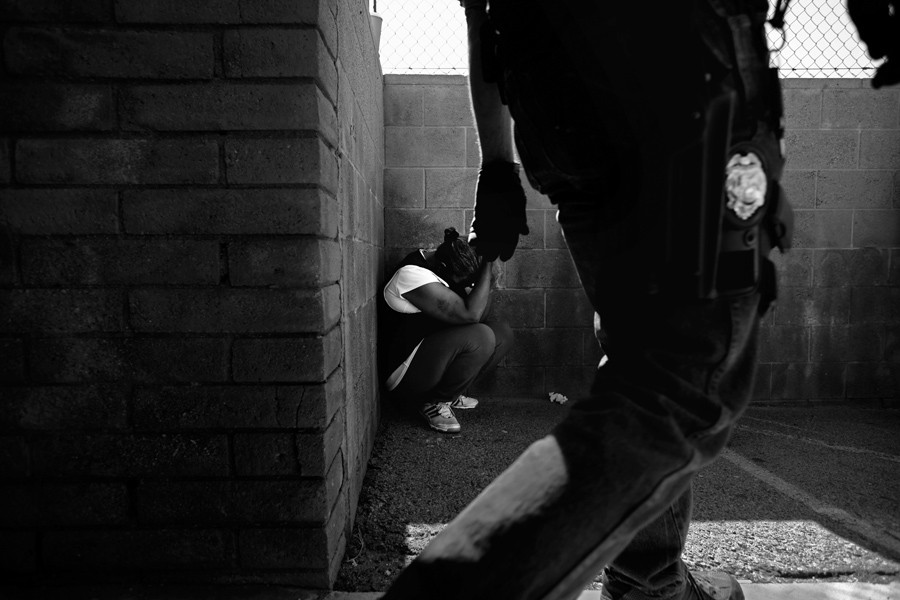 A woman waits to be questioned by authorities outside a suspected 'pill mill' in Sylmar, Calif., during an investigation by the Los Angeles County Sheriff's Department and other agencies.  (December 31, 2012)